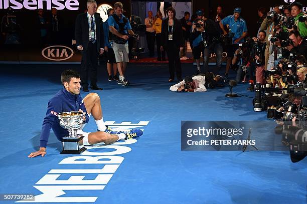 Serbia's Novak Djokovic poses for photographs with The Norman Brookes Challenge Cup after his victory during the men's singles final against...