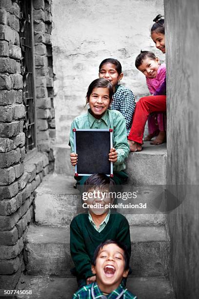 retrato de los estudiantes de la escuela pequeña en casa pizarra de retención - indian child fotografías e imágenes de stock