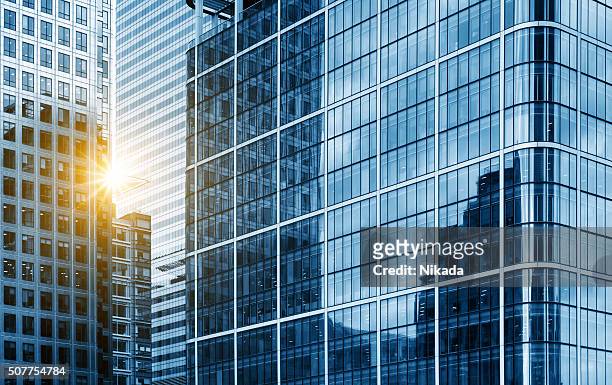 view of a contemporary glass skyscraper reflecting the blue sky - blue glass stock pictures, royalty-free photos & images