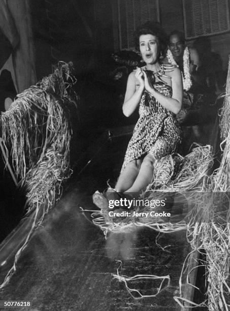 Entertainer Gypsy Rose Lee sitting on a slide at a costume party at the Hawaiian Room.