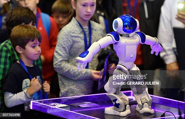 Children look at "NAO" a programmable humanoid robot developed by French robotics company Aldebaran Robotics during the Global Robot Expo in Madrid...