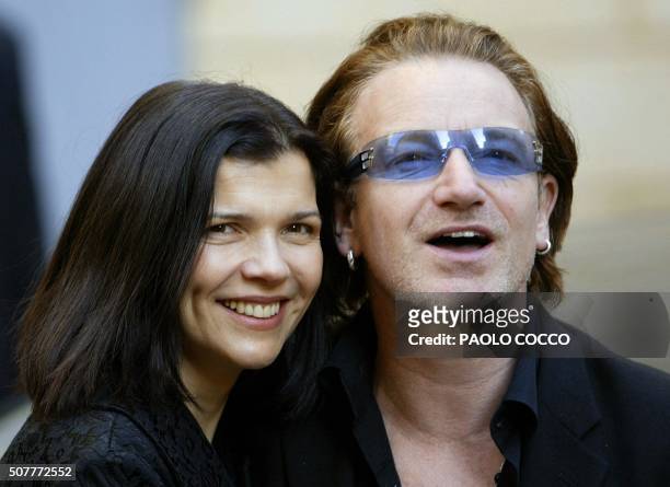 Irish singer Bono, lead singer of the rock group U2, smiles flanked by his wife Alison Stewart after attending the wedding of famous Italian tenor...