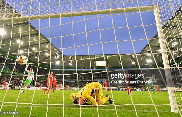 Despair for goalkeeper Timo Horn of Cologne as Julian Draxler of VfL Wolfsburg celebrates as he scores their first goal during the Bundesliga match...