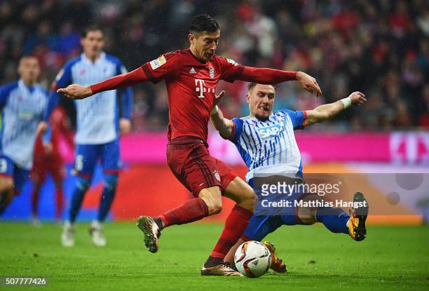 Robert Lewandowski of Bayern Munich beats Ermin Bicakcic of Hoffenheim to scores his and the team's second goal during the Bundesliga match between...