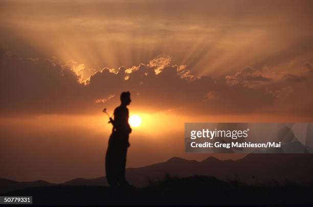 Kurdish peshmerga soldier standing atop a mountain overlooking Iraqi military postions, but within the protected area patroled by the US lead...