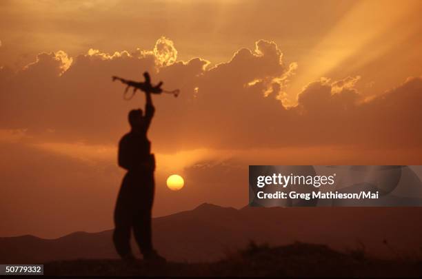 Kurdish peshmerga soldier standing atop a mountain overlooking Iraqi military postions, but within the protected area patroled by the US lead...