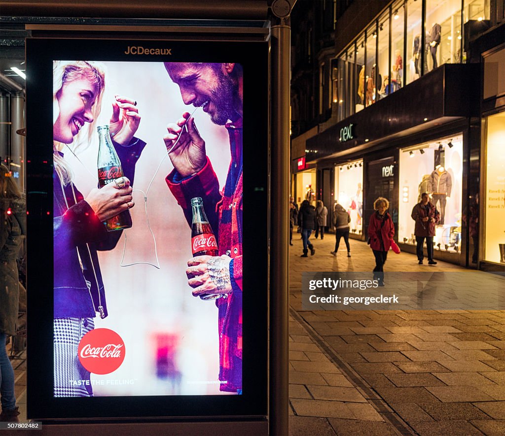 Illuminated Coca-Cola advertisement at night