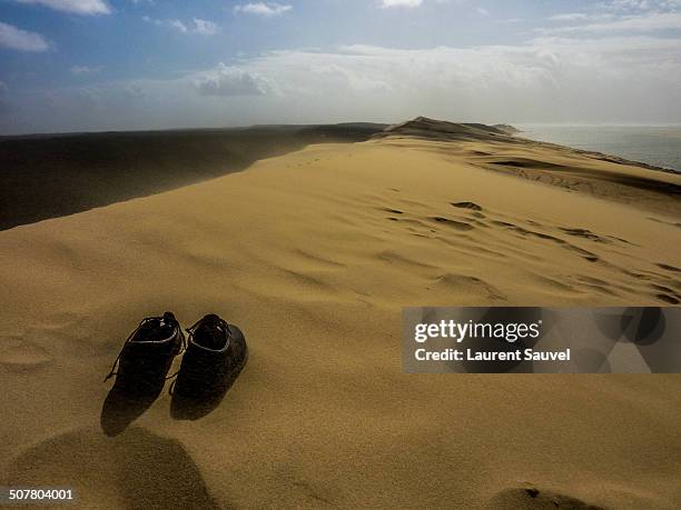 lonely shoes on the dune of pilat - laurent sauvel stock pictures, royalty-free photos & images