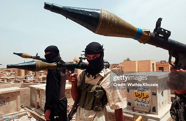 Armed gunmen of the al-Mehdi army man a defensive position in a cemetary of the holy city on April 28, 2004 Najaf, Iraq. Reports from the city...