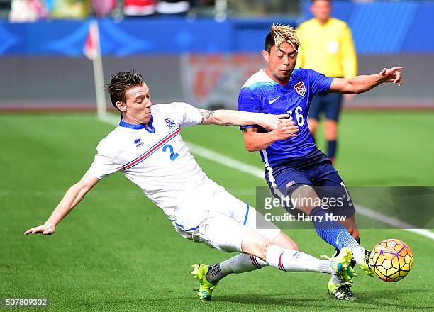 Lee Nguyen of the United States is taken down for the ball by Birkir Mar Saevarsson of Iceland during the first half at StubHub Center on January 31,...