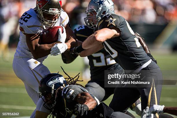 Team Rice running back Doug Martin of the Tampa Bay Buccaneers is stopped by Team Irvin cornerback Richard Sherman of the Seattle Seahawks and Sean...