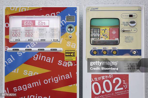 Boxes of Sagami Rubber Industries Co. Condoms, including the Sagami Original 0.02, left, sit on display inside vending machines outside the company's...