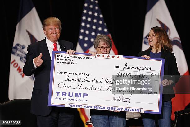 Donald Trump, president and chief executive of Trump Organization Inc. And 2016 Republican presidential candidate, left, awards a $100,000 check to a...