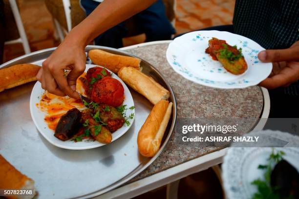 Omer Eltigani, a young British Sudanese pharmacist, serves Sudanese "Mahshi" that he prepared on January 11, 2016 at his aunt's house in Khartoum....