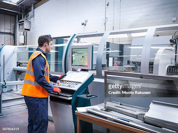 worker using robotic metal cutting machine in sheet metal factory - maschinenteil stock-fotos und bilder