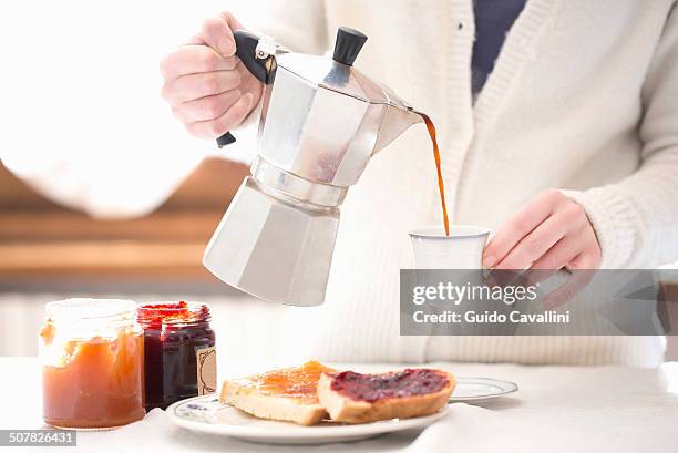 cropped shot of young woman pouring coffee for breakfast - coffee pot stock pictures, royalty-free photos & images