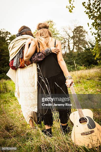 rear view of hippy girls walking through field with guitar - country to country festival 2013 day 2 stock-fotos und bilder