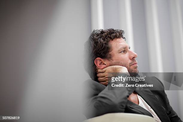 businessman leaning on elbow - boredom man fotografías e imágenes de stock