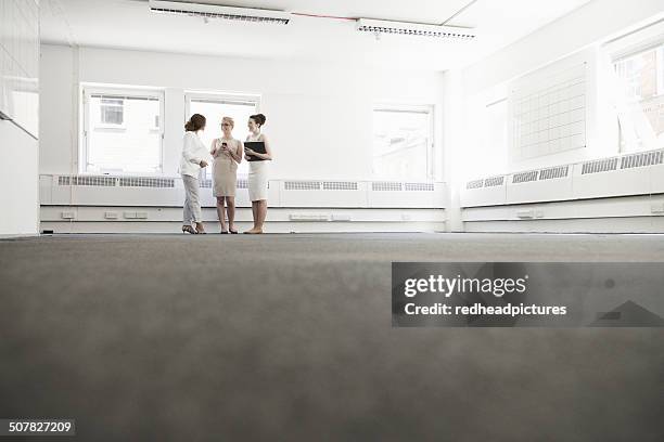 three young businesswomen planning in empty office - surface preparation stock pictures, royalty-free photos & images