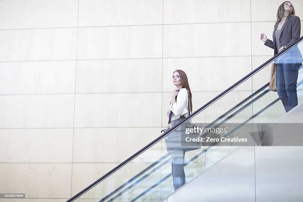 Businesswomen moving down on conference centre elevator