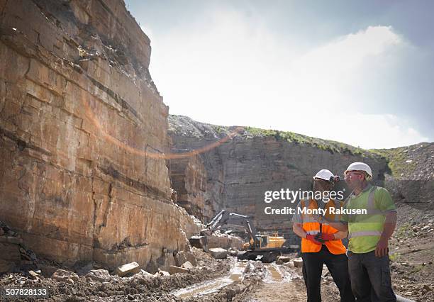 quarry workers inspecting rock strata in stone quarry - quarry work stock pictures, royalty-free photos & images