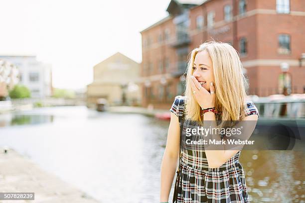 young woman standing by canal, leeds, england - leeds canal stock pictures, royalty-free photos & images