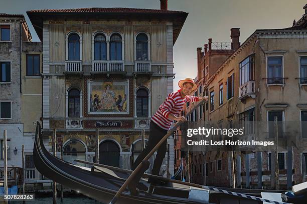 gondolier on grand canal, venice, veneto, italy - gondola traditional boat stockfoto's en -beelden
