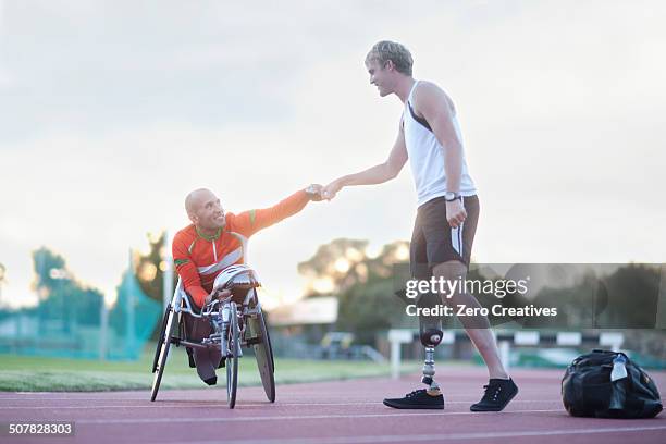 para-athletes doing fist bump - track and field team stock pictures, royalty-free photos & images