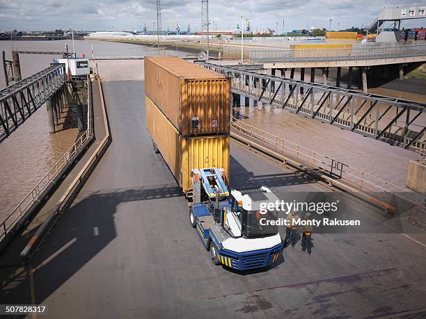 elevated view of shipping container and truck on ramp to ship - hull truck stock pictures, royalty-free photos & images