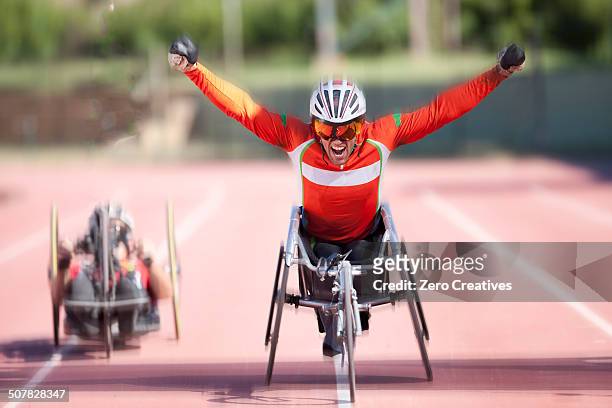 athlete at finishing line in para-athletic competition - sportler mit behinderung stock-fotos und bilder