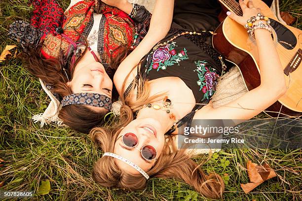 hippy girls lying in field with guitar - music festival grass stock pictures, royalty-free photos & images