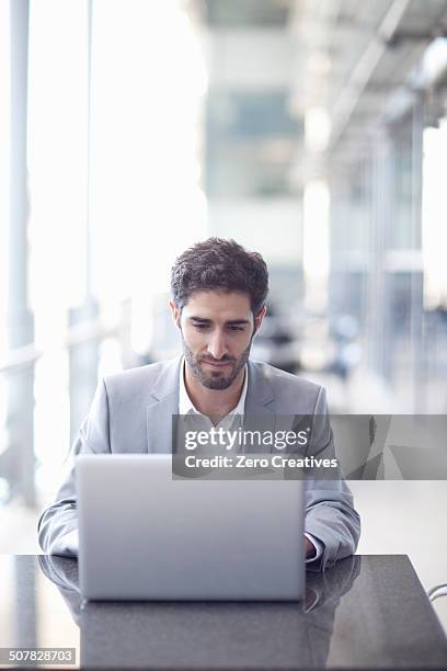 young businessman using laptop in conference centre - one zero conference stock pictures, royalty-free photos & images