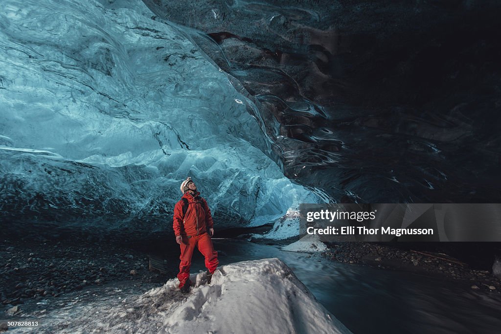 Man gazing upward in ice cave, Vatnajokull Glacier, Vatnajokull National Park, Iceland