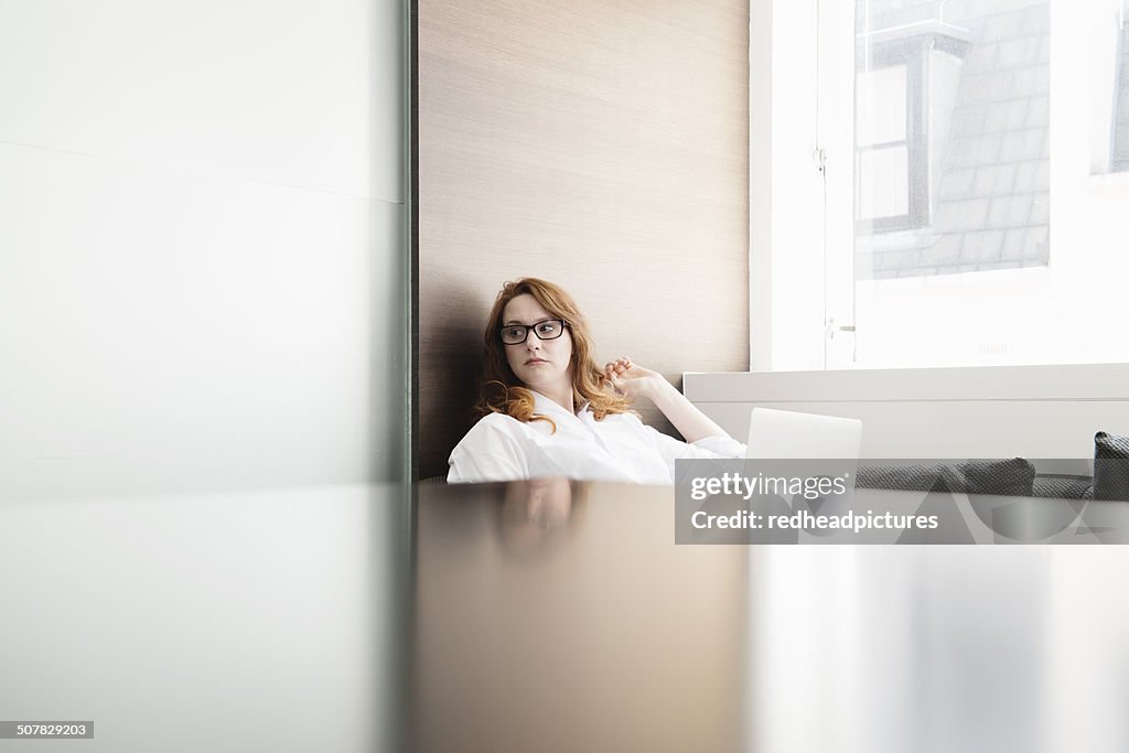 Mid adult businesswoman contemplating in new office