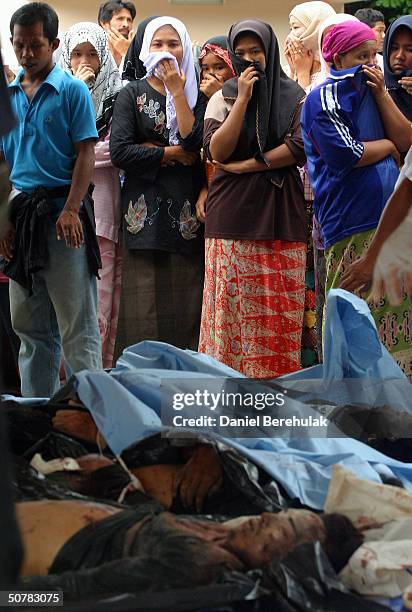 Muslim locals look over the unclaimed bodies of victims killed in Wednesday's deadly clash, during a mass funeral ceremony on April 29, 2004 in the...