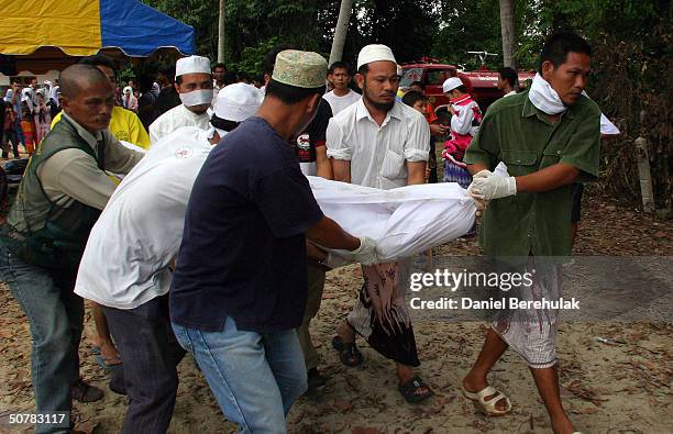 Villagers carry an unclaimed body of a victim killed in Wednesday's deadly clash, during a mass funeral ceremony on April 29, 2004 in the Pattani...