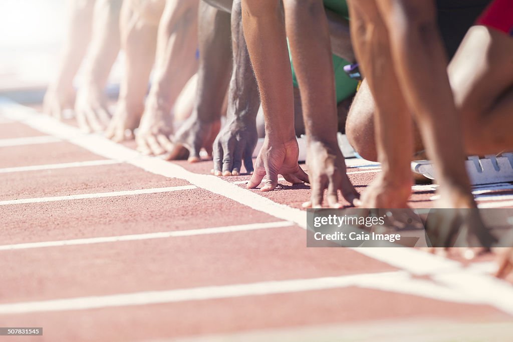 Runners poised at starting blocks on track