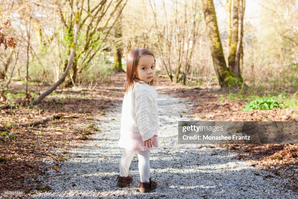 Baby girl walking on gravel path