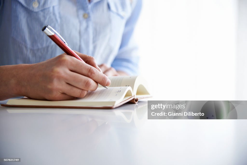 Mujer escribiendo en cuaderno