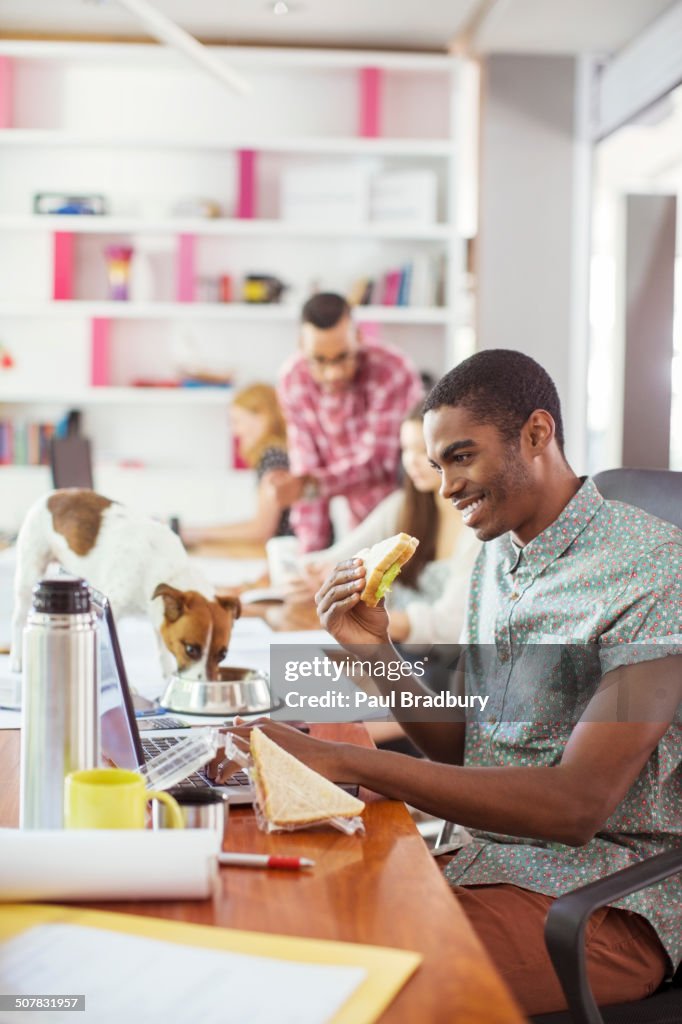 Man eating and working at conference tablet