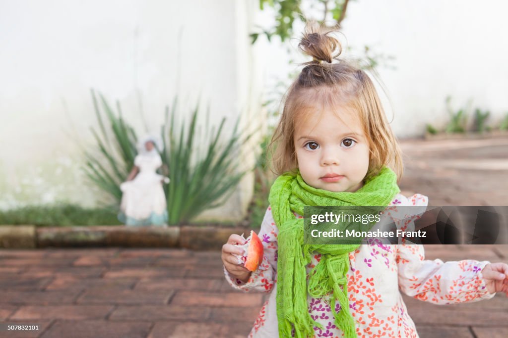 Baby girl eating fruit outdoors