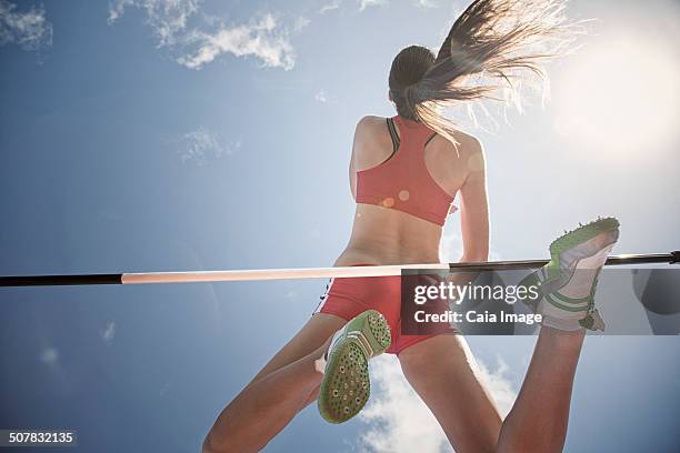 high jumper clearing bar - hochsprung stock-fotos und bilder