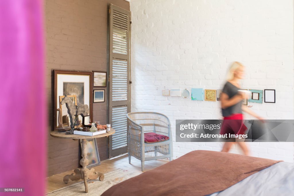 Blurred view of woman walking in bedroom