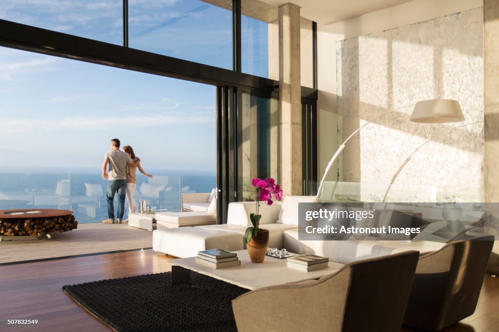 Paar steht auf dem Balkon des modernen Hauses