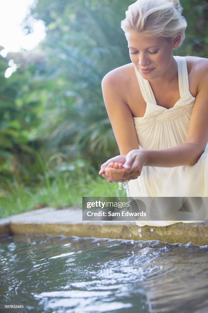 彼女の手にプールの水をカッピング女性