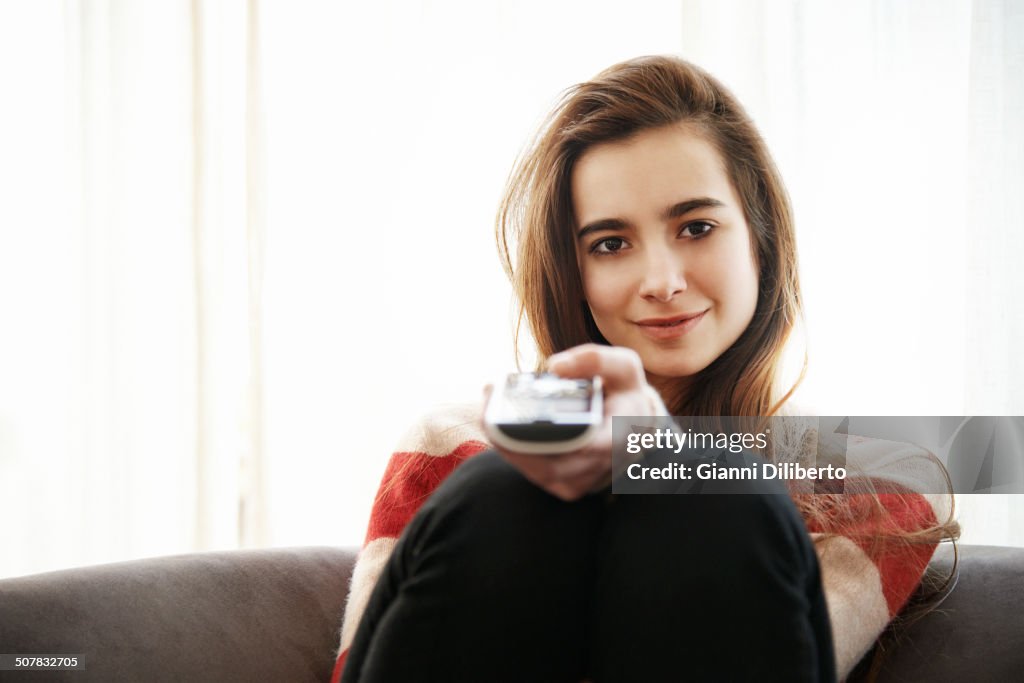 Teenage girl watching television on sofa