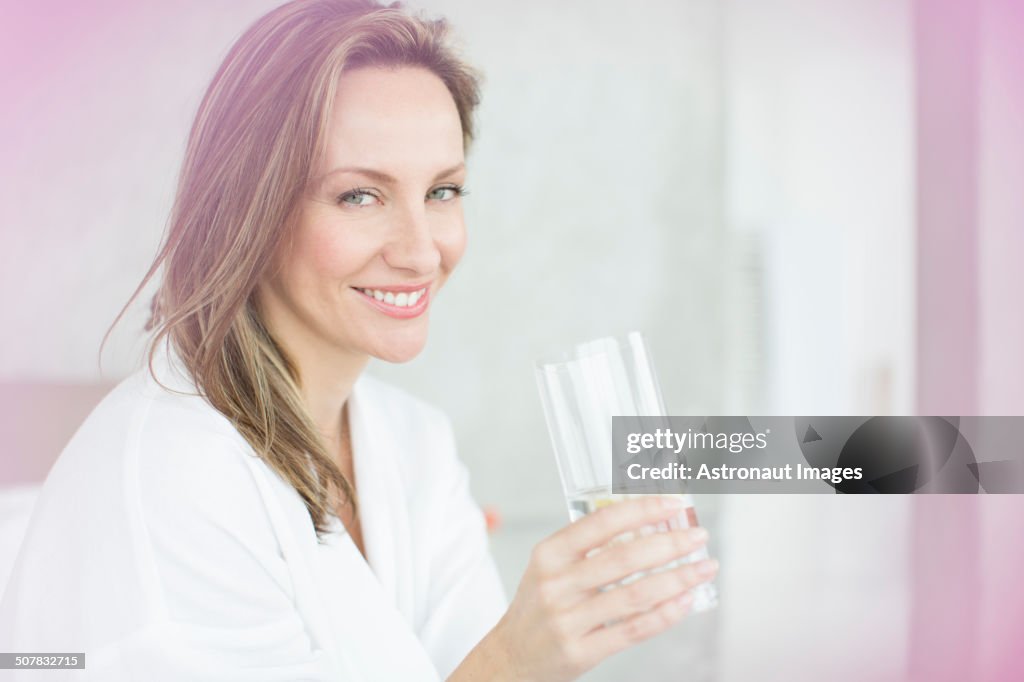 Donna che ha un bicchiere d'acqua in camera da letto