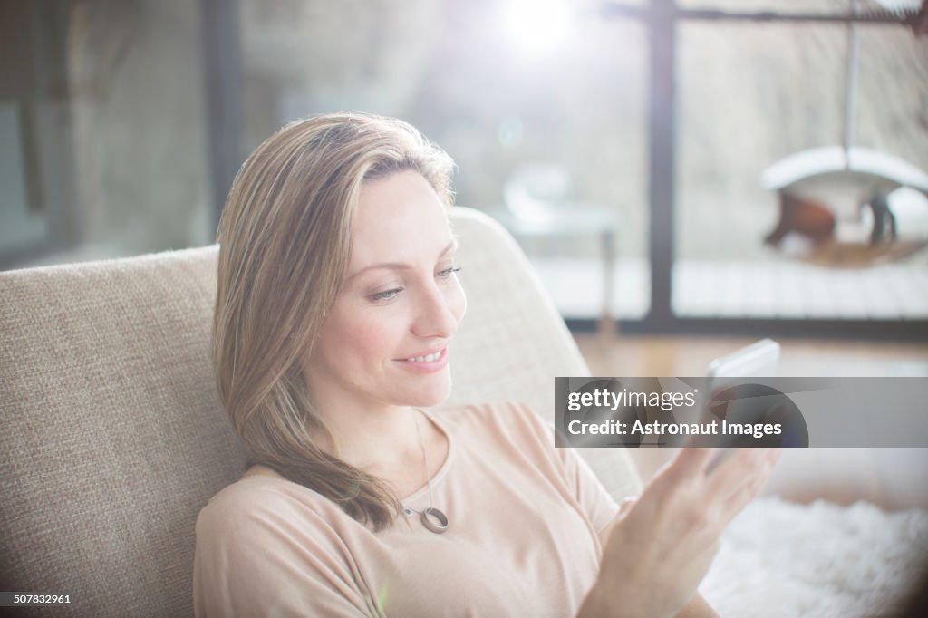 Frau mit Handy auf dem Sofa