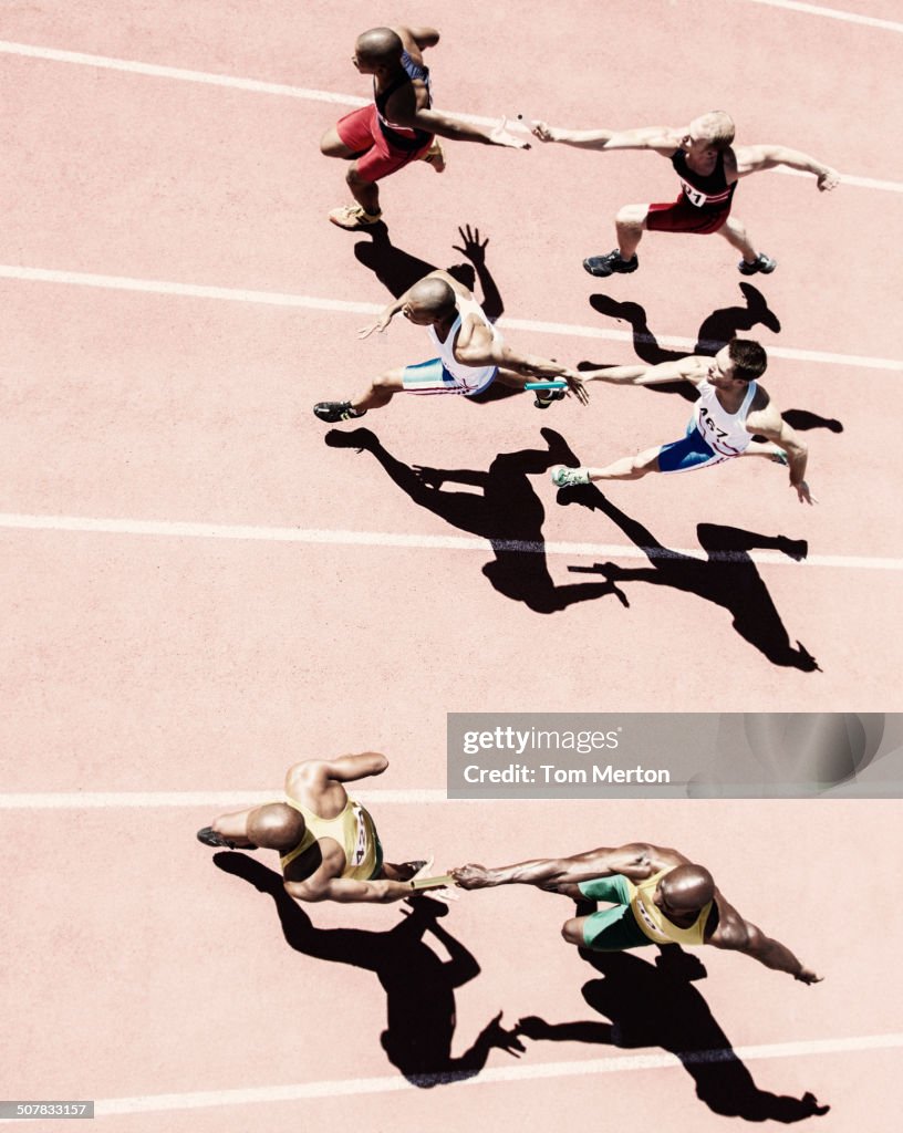 I corridori della staffetta consegnano i manganelli in pista