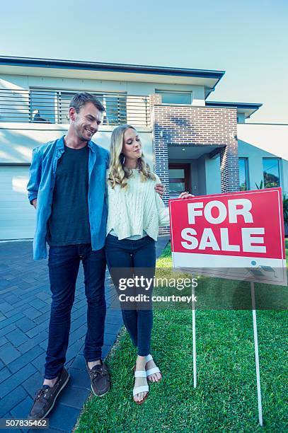 couple standing in front of a new home. - young couple shopping stock pictures, royalty-free photos & images